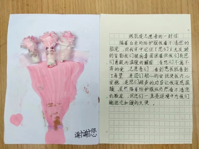 图为一位社区小朋友为医务人员送上感谢信及绘画作品